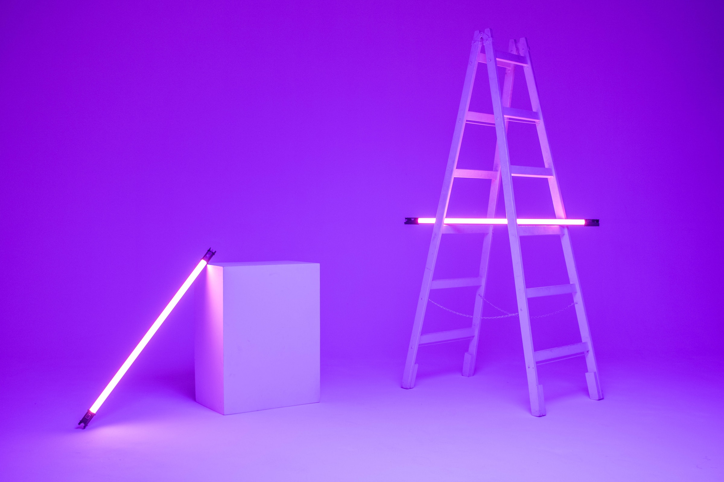 A photo of a ladder and box with purple neon lights